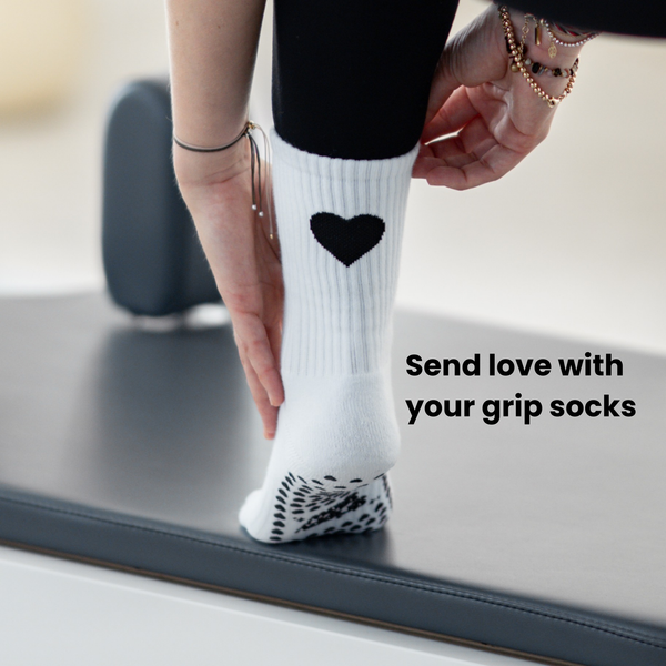 Close-Up der Pilates Socken mit schwarzem Herz und grippyglow Noppensohle – Reformer-ready, rutschfest und ästhetisch