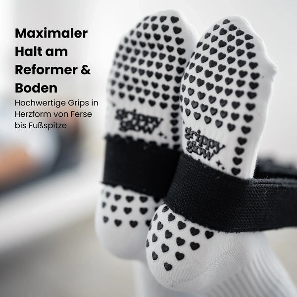 Sohlenansicht der weißen grippyglow Pilates Socken mit Herz-Noppen – Anti-Rutsch-Profil für sicheren Halt auf dem Reformer-Gerät