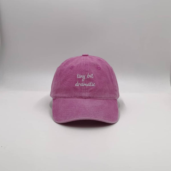 Schildmütze aus 100% Baumwolle in Pink mit einem eingestickten Spruch. Der Spruch lautet: tiny bit dramatic