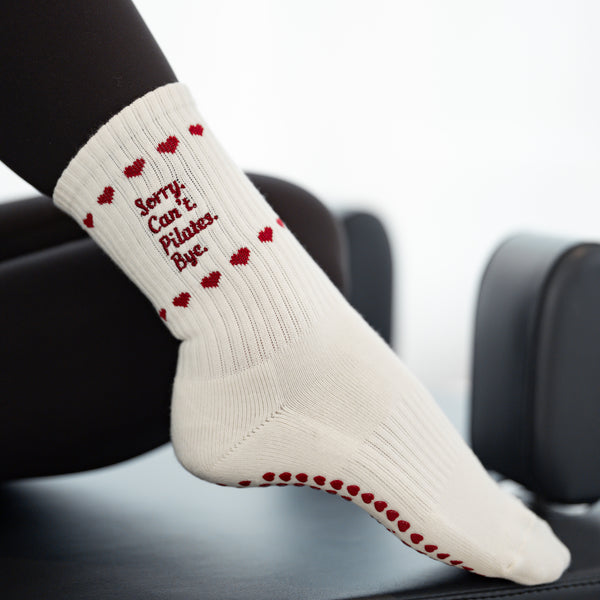 Beigefarbene Reformer Socken mit roten Herz-Noppen und Spruch ‚Sorry. Can’t. Pilates. Bye.‘ – funktionale und modische Anti-Rutsch Socken fürs Pilates Training