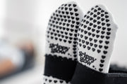 Sohlenansicht der weißen grippyglow Pilates Socken mit Herz-Noppen – Anti-Rutsch-Profil für sicheren Halt auf dem Reformer-Gerät