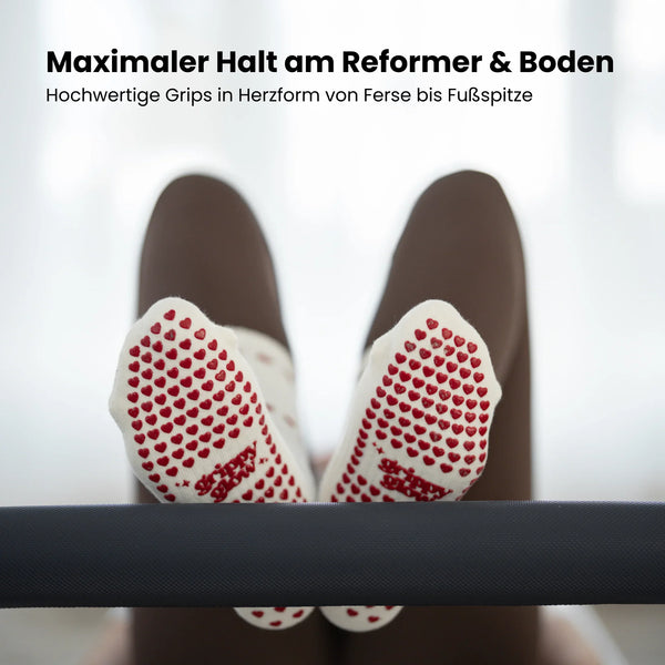 Beigefarbene Pilates Socken mit rutschfesten roten Herz-Noppen und grippyglow Logo – stylische Grip Socks für sicheren Halt im Reformer Studio