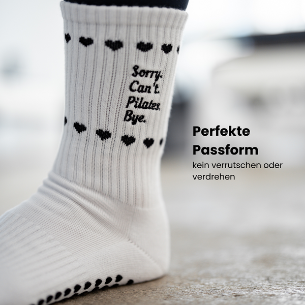 Detailaufnahme weißer Pilates Socken mit schwarzem Statement ‚Sorry. Can’t. Pilates. Bye.‘ und rutschfestem Herz-Grip – stylische Studio-Socken für sicheren Halt beim Pilates Training
