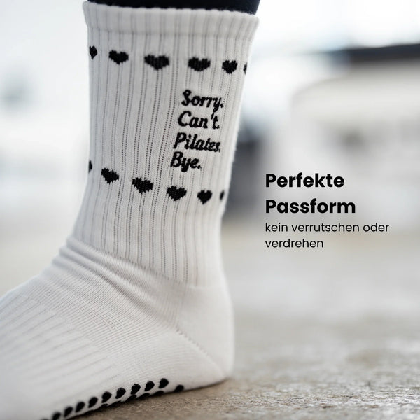 Detailaufnahme weißer Pilates Socken mit schwarzem Statement ‚Sorry. Can’t. Pilates. Bye.‘ und rutschfestem Herz-Grip – stylische Studio-Socken für sicheren Halt beim Pilates Training