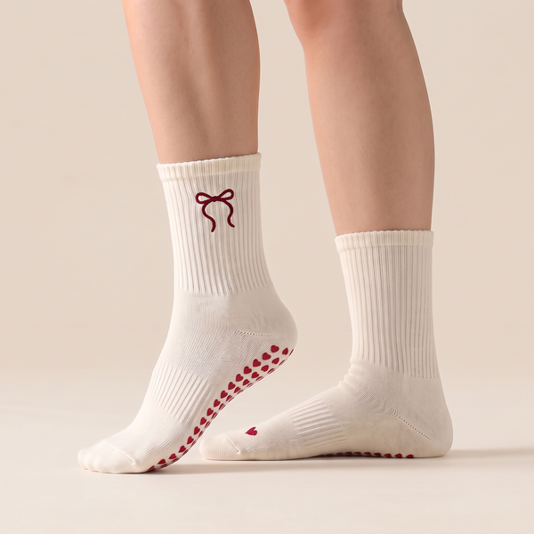 Getragene Bow Grip Pilates Socken von der Seite, herzförmige Grip-Noppen auf der Sohle sichtbar