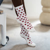 Lifestyleaufnahme: beigefarbene Pilates Socken mit roten Herzchen – trendige Studio-Socken für Reformer Training und Barre Workouts