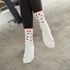 Beige Pilates Grip Socks mit roten Herzdetails und Rüschenkante, getragen im Studio auf einem Reformergerät. Perfekt für Reformer Pilates, Yoga, Barre und Freizeit