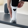 Close-Up der Pilates Socken mit schwarzem Herz und grippyglow Noppensohle – Reformer-ready, rutschfest und ästhetisch