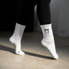 Bewegungsaufnahme: weiße Pilates Socken mit schwarzer Schleife und Anti-Rutsch-Noppen beim Training – stylische Studio-Socken für Reformer Pilates